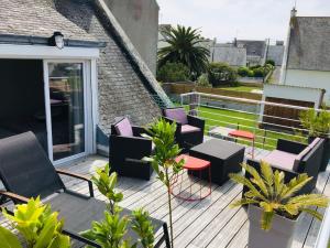 een patio met stoelen en tafels op een balkon bij Maison avec Jardin,Terrasse,bar,baby foot 4-6 pers in Le Guilvinec