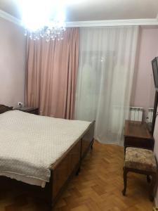 1 dormitorio con cama y lámpara de araña en Parso Apartment, en Batumi