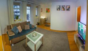 uma sala de estar com um sofá e uma televisão em Komfortowy Apartament Belweder em Olsztyn