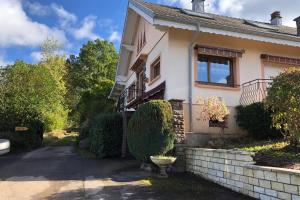 une maison avec un grand bush devant elle dans l'établissement Gite des Hauts Jardins, à Ban-sur-Meurthe-Clefcy