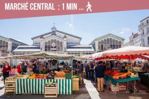 a market with fruit and vegetables in front of a building at ღ Marché Central • Au cœur de ville & Spacieux in La Rochelle