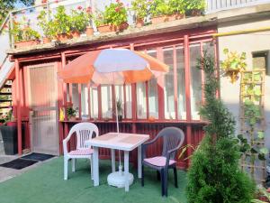 a table with two chairs and an umbrella on a patio at Cosy Studio-House with Terrace in Târgu-Mureş