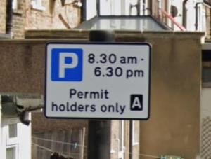 a parking sign on a pole on a street at StayEasy En-Suite London in London