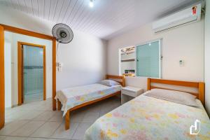 ein Schlafzimmer mit zwei Betten und einem Fenster in der Unterkunft Casa com 05 dormitórios ideal as férias na praia in Canto Grande