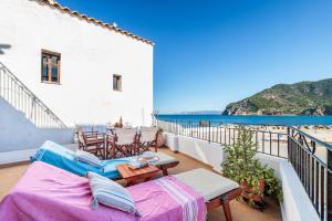 a balcony with a table and chairs and the ocean at villa Yiannoula in Skopelos Town