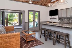 a kitchen with a bar and some chairs and tables at C4 - Villa McDonald in San Pedro