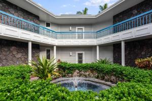 a building with a fountain in the courtyard at Mauna Loa Village with Pools, Tennis & Pickleball in Kailua-Kona