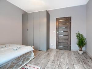 a bedroom with a bed and a potted plant at Gdańsk Central Business Apartments with Parking by Rentujemy in Gdańsk