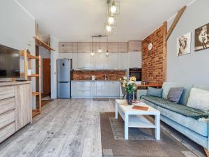 a living room with a couch and a table at Gdańsk Central Business Apartments with Parking by Rentujemy in Gdańsk