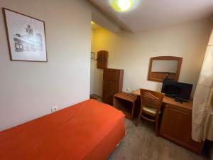 a bedroom with a bed and a desk with a computer at Pirina Club Hotel in Bansko