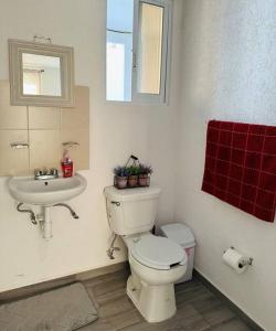 La salle de bains est pourvue de toilettes blanches et d'un lavabo. dans l'établissement Depa Meraki More, à Morelia