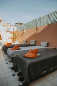 une rangée de lits alignés sur un mur dans l'établissement Riad Dar Coram, à Marrakech