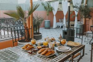 een tafel met ontbijtproducten op een balkon bij Riad Dar Coram in Marrakesh