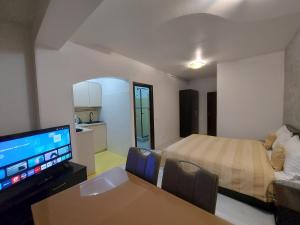 sala de estar con cama, TV y sofá en Aparthotel La Manastire en Sinaia
