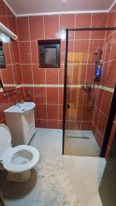 y baño con ducha, aseo y lavamanos. en Aparthotel La Manastire en Sinaia