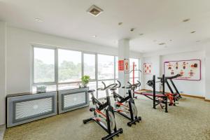 a gym with three exercise bikes in a room with windows at TTC Hotel Deluxe Airport in Ho Chi Minh City