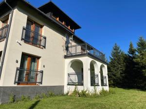 een wit gebouw met balkons aan de zijkant bij Apartamenty Brenna Klimorówka in Brenna