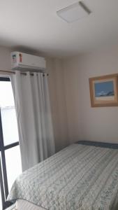a bedroom with a bed and a window at Meu verao em ITAPEMA in Itapema