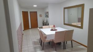 a dining room with a table and chairs and a mirror at Meu verao em ITAPEMA in Itapema