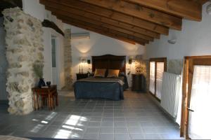 a bedroom with a bed and a stone wall at La Llar D'aitana in Alcoleja