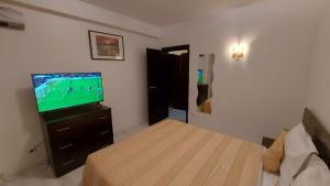 1 dormitorio con 1 cama y TV en una habitación en Aparthotel La Manastire en Sinaia
