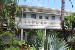 an apartment building with a balcony and palm trees at Kauai Palms Hotel in Lihue