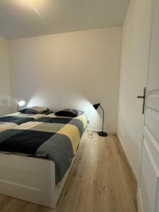 Un dormitorio con una cama y una lámpara. en Eliya, en Romilly-sur-Seine