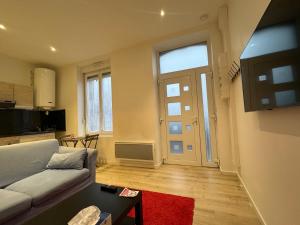 a living room with a couch and a door at Eliya in Romilly-sur-Seine
