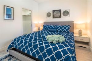 a bedroom with a blue and white bed and two lamps at Cayman Luxury Rentals at The Grove in Upper Land