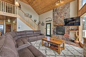 a living room with a couch and a fireplace at Spacious Mountain-View Cabin By Angel Fire Resort in Angel Fire