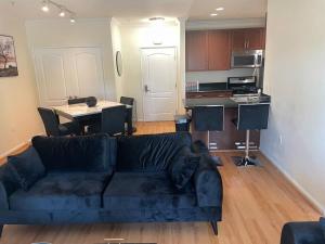a living room with a blue couch and a kitchen at Luxury 2 bedroom apartment in downtown LA! in Los Angeles