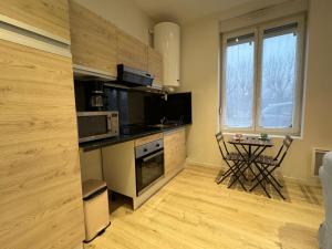 a small kitchen with a table and a window at Eliya in Romilly-sur-Seine +18 photos