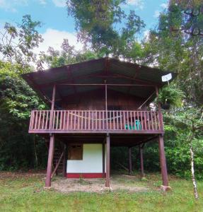 uma pequena casa com um deque em cima em Finca Ixobel em Ixobel