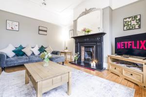 a living room with a fireplace and a tv at Spacious 5BR House with Garden & Parking - Near Metro in Jesmond