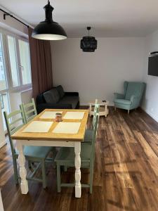 a dining table and chairs in a living room at Przystań Północy in Suwałki