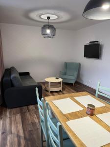 a living room with a table and a couch at Przystań Północy in Suwałki