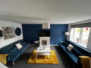 een blauwe woonkamer met een bank en een tafel bij Ripon House in Dallington