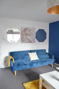 a blue couch sitting in a living room at Ripon House in Dallington