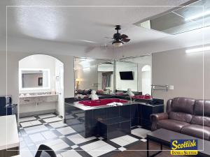 a living room with a sink and a mirror at Scottish Inn & Suites Sam Houston Parkway in Houston