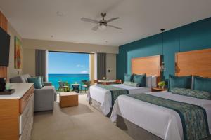 a hotel room with two beds and a view of the ocean at Dreams Cozumel Cape Resort & Spa in Cozumel +51 photos