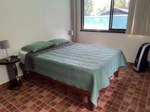 een slaapkamer met een bed in een kamer met een raam bij Asis wildlife sanctuary apartment 30 min from La Fortuna in Jabillos