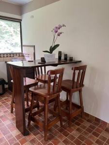 una mesa con cuatro sillas y una mesa con flores. en Asis wildlife sanctuary apartment 30 min from La Fortuna, en Jabillos