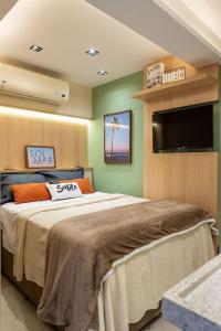 a bedroom with a large bed and a flat screen tv at PREMIUM Maravilhoso Estúdio sofisticado e completo em Ipanema in Rio de Janeiro