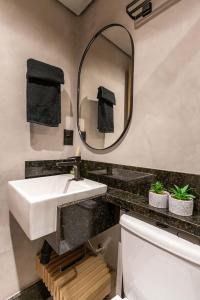 a bathroom with a white sink and a mirror at PREMIUM Maravilhoso Estúdio sofisticado e completo em Ipanema in Rio de Janeiro
