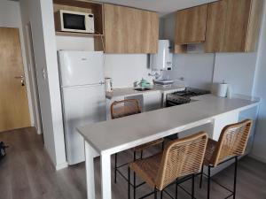 a kitchen with a white refrigerator and a table with chairs at Monoambiente céntrico a estrenar in Rosario