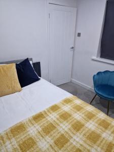 um quarto com uma cama e uma cadeira azul em Cosy and Unique Bedroom In Gateshead em Sheriff Hill