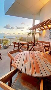 a wooden table on a patio with a view of the ocean at Bugan Paiva flatpaivahome in Recife