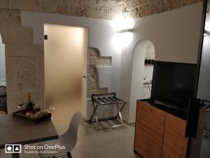 a living room with a flat screen tv on a dresser at Suite Atmosfera in Ostuni