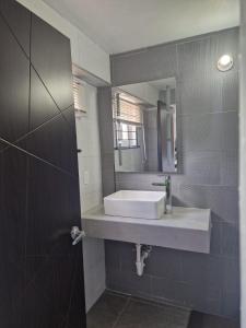 y baño con lavabo y espejo. en Amharic, en Kingston