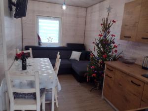 a living room with a table and a christmas tree at Szary Domek w Karkonoszach in Podgórzyn